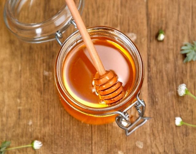 木のテーブルに置かれた蜂蜜の瓶