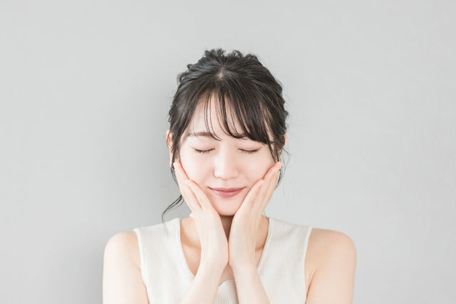 目を閉じて微笑むリラックス中の女性