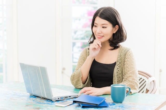 ラップトップで思案する女性